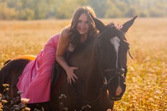 una ragazza sorridente su un cavallo in un vestito in fotografia stock una ragazza sorridente su un cavallo in un vestito in fotografia stock