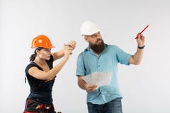Una riunione maschio dell'ingegnere o dell'architetto con un appaltatore della donna della costruzione su fondo bianco immagini stock Una riunione maschio dell'ingegnere o dell'architetto con un appaltatore della donna della costruzione su fondo bianco immagini stock