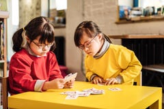 Una sensibilità soleggiata di due bambini in questione nell'esame imparante le carte fotografie stock Una sensibilità soleggiata di due bambini in questione nell'esame imparante le carte fotografie stock