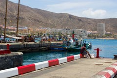 Una sola pesca masculina del embarcadero concreto en el puerto deportivo apretado en Los Cristianos en la isla de Tenerife en imagenes de archivo Una sola pesca masculina del embarcadero concreto en el puerto deportivo apretado en Los Cristianos en la isla de Tenerife en imagenes de archivo