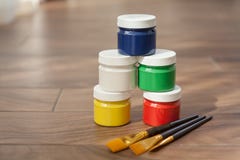 Una tavolozza multicolore delle pitture e di tre spazzole fotografia stock Una tavolozza multicolore delle pitture e di tre spazzole fotografia stock