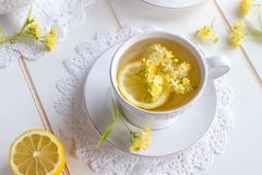 Una taza de infusión de hierbas con las flores del tilo fotos de archivo Una taza de infusión de hierbas con las flores del tilo fotos de archivo