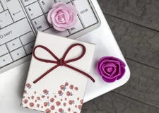Una vista superiore di due rose e del computer portatile bianco su fondo fotografie stock Una vista superiore di due rose e del computer portatile bianco su fondo fotografie stock