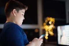 Unbeaufsichtigter Junge, der am Handy nachts plaudert und schreibt lizenzfreie stockfotos Unbeaufsichtigter Junge, der am Handy nachts plaudert und schreibt lizenzfreie stockfotos