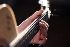 Under bright lighting, a person plays a guitar melody royalty free stock photos Under bright lighting, a person plays a guitar melody royalty free stock photos