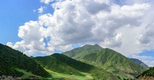Under the clear weather, the blue sky, the white clouds, the green mountains make up the beautiful scenery. In Qinghai province of China, the beautiful scenery Royalty Free Stock Photos Under the clear weather, the blue sky, the white clouds, the green mountains make up the beautiful scenery. In Qinghai province of China, the beautiful scenery Royalty Free Stock Photos