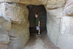 Undersökande grotta för pojke royaltyfri fotografi Undersökande grotta för pojke royaltyfri fotografi