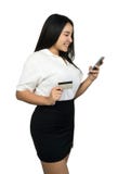 Une belle femme asiatique tenant une carte de crédit et regardant son smartphone photos stock Une belle femme asiatique tenant une carte de crédit et regardant son smartphone photos stock