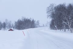 Une belle route blanche par la forêt en Norvège centrale avec des poteaux de sécurité Photos stock Une belle route blanche par la forêt en Norvège centrale avec des poteaux de sécurité Photos stock