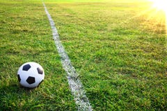 Une bille ou un football de football dans le stade avec le coucher du soleil image libre de droits Une bille ou un football de football dans le stade avec le coucher du soleil image libre de droits