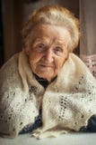 Une femme agée, un portrait se reposant à la table photo libre de droits Une femme agée, un portrait se reposant à la table photo libre de droits