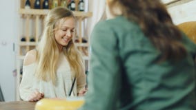 Une femme attirante achète la nourriture de petit stock, la vue du côté du compteur clips vidéos Une femme attirante achète la nourriture de petit stock, la vue du côté du compteur clips vidéos