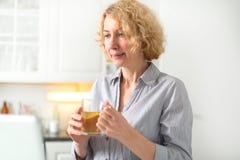 Une femme d'une cinquantaine d'années tient une tasse de thé image libre de droits Une femme d'une cinquantaine d'années tient une tasse de thé image libre de droits