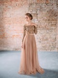 Une fille blonde pose dans une robe arénacée et brune molle avec un dessus de dentelle et avec une jupe somptueuse de Tulle L'ima images stock Une fille blonde pose dans une robe arénacée et brune molle avec un dessus de dentelle et avec une jupe somptueuse de Tulle L'ima images stock