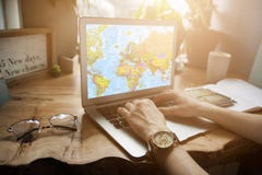Une fille de voyageur dans un café avec un ordinateur portable recherche l'information sur où voler sur un voyage sur une carte d images libres de droits Une fille de voyageur dans un café avec un ordinateur portable recherche l'information sur où voler sur un voyage sur une carte d images libres de droits