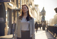 Une fille rousse marche le long de la rue ensoleillée photo libre de droits Une fille rousse marche le long de la rue ensoleillée photo libre de droits