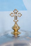 Une grande croix sur le couvercle d'une grande cuvette avec de l'eau pour le baptême infantile photos libres de droits Une grande croix sur le couvercle d'une grande cuvette avec de l'eau pour le baptême infantile photos libres de droits