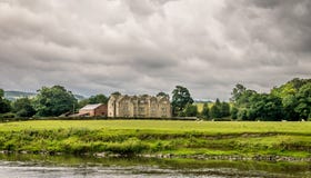 Une grande vieille maison de ferme près d'une rivière avec des nuages de tempête image libre de droits Une grande vieille maison de ferme près d'une rivière avec des nuages de tempête image libre de droits