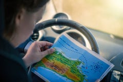 Une jeune femme conduit une voiture et regarde la carte Carte de l'île grecque de Kos La capitale de Kos image stock Une jeune femme conduit une voiture et regarde la carte Carte de l'île grecque de Kos La capitale de Kos image stock