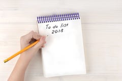Une liste de remue-ménage dans un bloc-notes sur des spirales Place pour le texte Une main du ` s de fille tient un crayon Photos libres de droits Une liste de remue-ménage dans un bloc-notes sur des spirales Place pour le texte Une main du ` s de fille tient un crayon Photos libres de droits