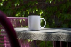 Une longue tasse de café blanc vide soloe sur une table de parc photographie stock libre de droits Une longue tasse de café blanc vide soloe sur une table de parc photographie stock libre de droits