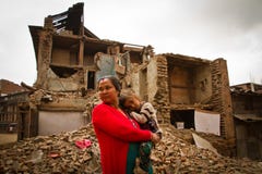 Une mère et un enfant en dehors d'un tremblement de terre ont ruiné la maison dans Bhaktap photographie stock Une mère et un enfant en dehors d'un tremblement de terre ont ruiné la maison dans Bhaktap photographie stock