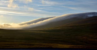 Une nuit d'été en Islande Les nuages flottent en bas d'une montagne image libre de droits Une nuit d'été en Islande Les nuages flottent en bas d'une montagne image libre de droits