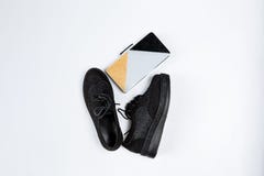 Une paire de chaussures noires avec les insertions brillantes sur une semelle ?paisse et un sac d'embrayage de trois-couleur avec photos stock Une paire de chaussures noires avec les insertions brillantes sur une semelle ?paisse et un sac d'embrayage de trois-couleur avec photos stock