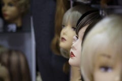 Une rangée des femmes de mannequins sur une étagère dans un magasin de perruque image stock Une rangée des femmes de mannequins sur une étagère dans un magasin de perruque image stock