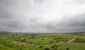 Une route sinueuse par les pasteurs verts photo stock Une route sinueuse par les pasteurs verts photo stock