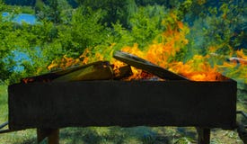 Une rôtissoire avec des charbons brûlants et une flamme rouge images stock Une rôtissoire avec des charbons brûlants et une flamme rouge images stock