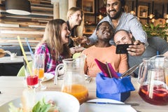 Une soci?t? des jeunes multiculturels dans un caf? mangeant de la pizza, cocktails potables, ayant l'amusement image stock Une soci?t? des jeunes multiculturels dans un caf? mangeant de la pizza, cocktails potables, ayant l'amusement image stock