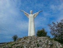Une statue blanche comme neige énorme du Christ sur le dessus d'une montagne contre un ciel bleu et des nuages dans Maratea, Basi photographie stock libre de droits Une statue blanche comme neige énorme du Christ sur le dessus d'une montagne contre un ciel bleu et des nuages dans Maratea, Basi photographie stock libre de droits