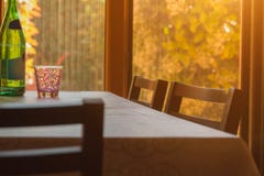 Une table avec des chaises se tient devant une fenêtre dans laquelle le soleil brille, architecture à la maison, confort à la mai photo stock Une table avec des chaises se tient devant une fenêtre dans laquelle le soleil brille, architecture à la maison, confort à la mai photo stock