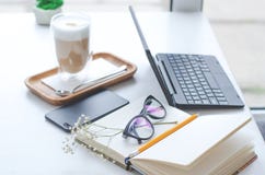 Une table dans un café lumineux avec des détails de travail de latte et d'indépendant photographie stock Une table dans un café lumineux avec des détails de travail de latte et d'indépendant photographie stock