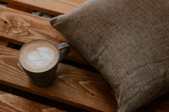 Une tasse de café sur un fond en bois avec un oreiller gris, temps de café photos libres de droits Une tasse de café sur un fond en bois avec un oreiller gris, temps de café photos libres de droits