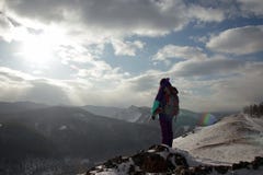 Une touriste seule de jeune femme se tient au bord d'une falaise et apprécie le paysage des montagnes images stock Une touriste seule de jeune femme se tient au bord d'une falaise et apprécie le paysage des montagnes images stock