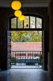 Une vue d'un balcon à l'extrémité du couloir avec la boule a formé des lampes et des ferronneries image libre de droits Une vue d'un balcon à l'extrémité du couloir avec la boule a formé des lampes et des ferronneries image libre de droits
