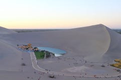 Une vue de distance de Crescent Lake a entouré par la montagne Mingsha de Faire écho-sable photographie stock Une vue de distance de Crescent Lake a entouré par la montagne Mingsha de Faire écho-sable photographie stock