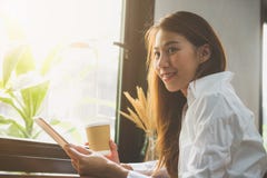 Ung affärskvinna i vitt klänningsammanträde på tabellen i kafé och handstil i anteckningsbok Asiatisk kvinna som använder minnest Arkivbilder Ung affärskvinna i vitt klänningsammanträde på tabellen i kafé och handstil i anteckningsbok Asiatisk kvinna som använder minnest Arkivbilder