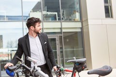 Ung affärsman med en cykel royaltyfri fotografi Ung affärsman med en cykel royaltyfri fotografi