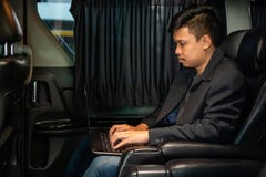 Ung affärsman som använder mobiltelefonen och bärbara datorn i bil royaltyfria foton Ung affärsman som använder mobiltelefonen och bärbara datorn i bil royaltyfria foton