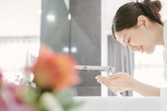 Ung asiat WWoman som tvättar hennes framsida royaltyfri bild Ung asiat WWoman som tvättar hennes framsida royaltyfri bild