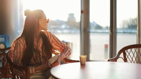 Ung attraktiv kvinna i röd solglasögon med minnestavladatorsammanträde i kafé Härlig flicka, i flygplats eller shoppping arkivfilmer Ung attraktiv kvinna i röd solglasögon med minnestavladatorsammanträde i kafé Härlig flicka, i flygplats eller shoppping arkivfilmer