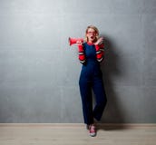 Ung blond flicka i jeans som beklär med megaphoone arkivfoton Ung blond flicka i jeans som beklär med megaphoone arkivfoton