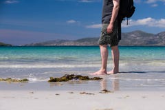 Ung caucasian man som tar en gå på en vit sandig strand med turkosvatten på hans semester arkivbilder Ung caucasian man som tar en gå på en vit sandig strand med turkosvatten på hans semester arkivbilder