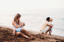 Ung familj med två litet barnbarn på stranden på sommarferie royaltyfria foton Ung familj med två litet barnbarn på stranden på sommarferie royaltyfria foton