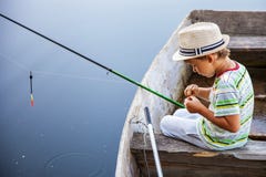 Ung fiskare som fångar fisken på fisk-stången Royaltyfri Foto Ung fiskare som fångar fisken på fisk-stången Royaltyfri Foto
