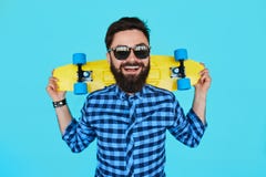 Ung hipsterman med en skateboard royaltyfria bilder Ung hipsterman med en skateboard royaltyfria bilder