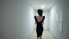 Ung härlig flicka i kontoret, i aftonklänningen som promenerar korridoren långsam rörelse lager videofilmer Ung härlig flicka i kontoret, i aftonklänningen som promenerar korridoren långsam rörelse lager videofilmer